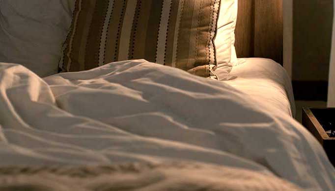 Bedbugs in bed with white sheets